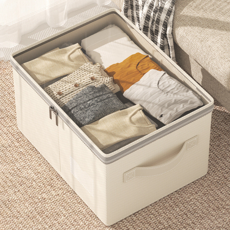Cream linen-cotton storage box open, neatly holding folded sweaters with clear zip lid.