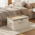 Cream linen-cotton storage box with clear zip lid and handles, placed beside a bed.
